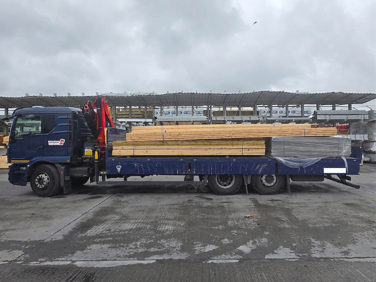 JBC Deliveries flatbed loaded with timber in a builders merchants yard